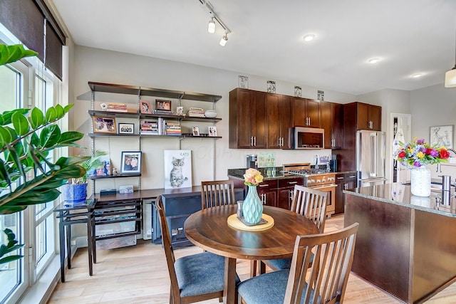 dining space featuring rail lighting and light hardwood / wood-style floors