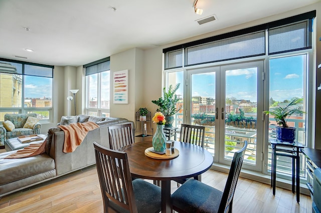 dining space featuring french doors and light wood-type flooring