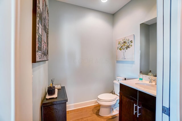 bathroom with hardwood / wood-style floors, vanity, and toilet