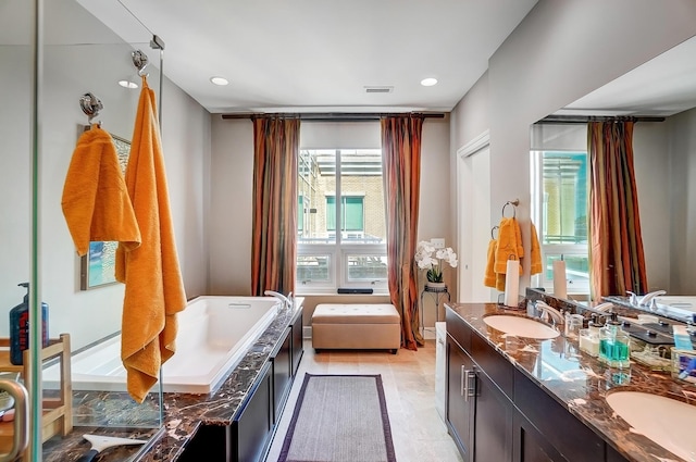 bathroom featuring a washtub, vanity, and tile patterned flooring