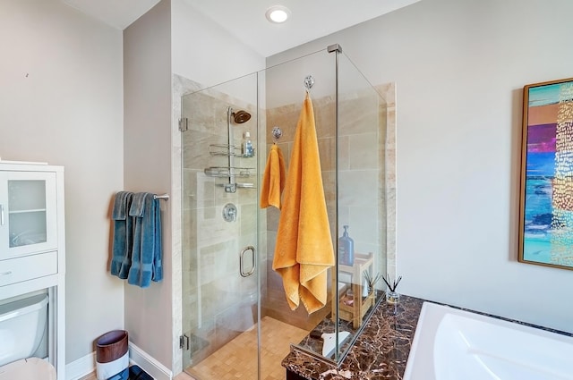 bathroom featuring toilet and a shower with door