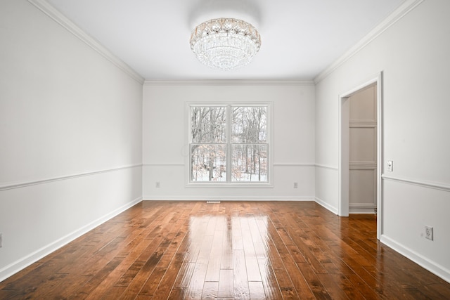 empty room with an inviting chandelier, crown molding, and dark hardwood / wood-style flooring