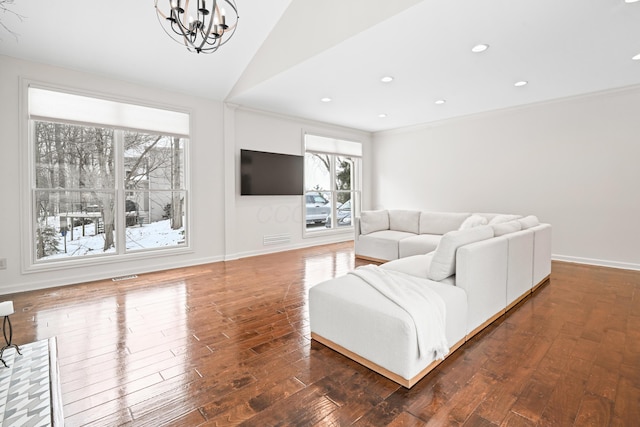 living room featuring dark wood-type flooring, vaulted ceiling, and a chandelier