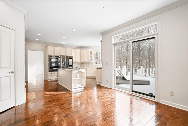 kitchen featuring tasteful backsplash, a breakfast bar area, hardwood / wood-style flooring, a center island, and stainless steel refrigerator with ice dispenser