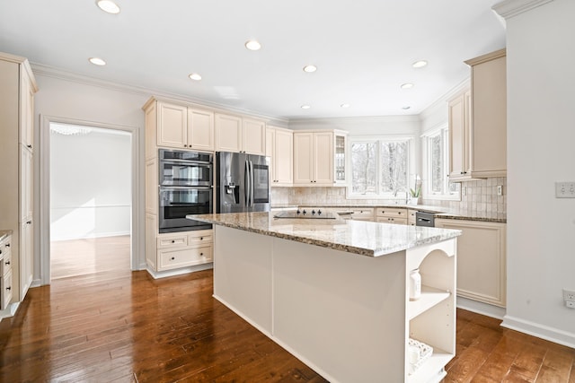 kitchen featuring dark wood-type flooring, light stone counters, a kitchen island, stainless steel appliances, and backsplash