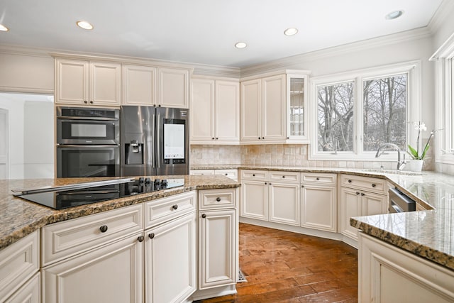 kitchen featuring appliances with stainless steel finishes, stone countertops, tasteful backsplash, crown molding, and dark wood-type flooring