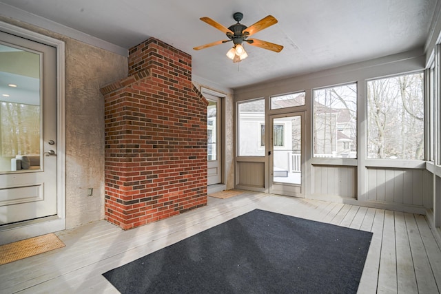 unfurnished sunroom with ceiling fan