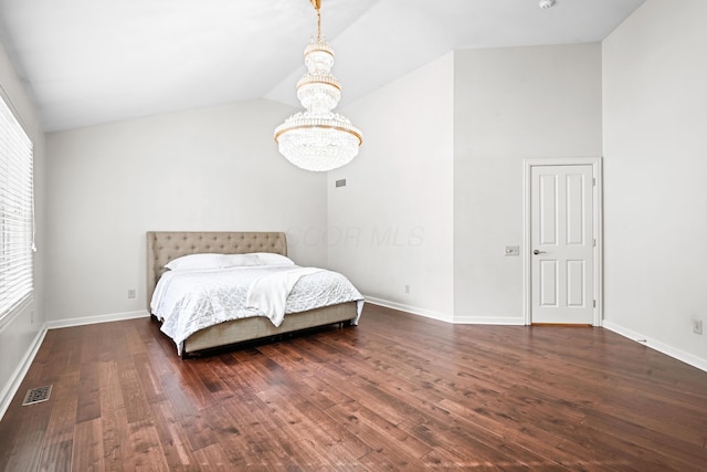 bedroom featuring lofted ceiling, dark wood-type flooring, and a chandelier