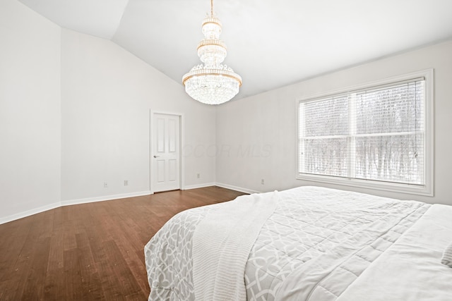 bedroom with multiple windows, lofted ceiling, dark wood-type flooring, and a notable chandelier