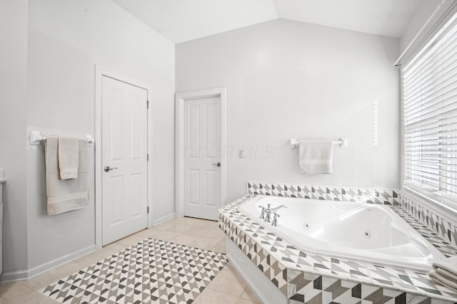 bathroom with lofted ceiling, tiled bath, and tile patterned floors