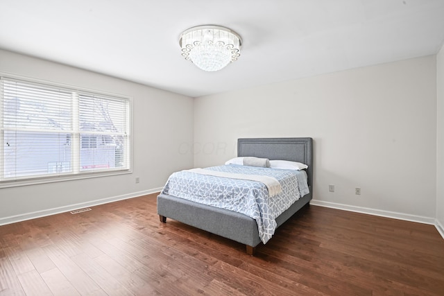 bedroom with dark hardwood / wood-style floors