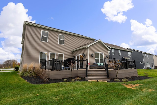 rear view of house featuring a lawn and a deck