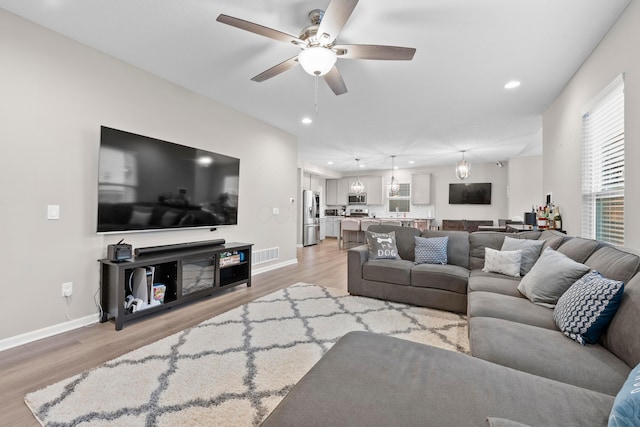 living room with ceiling fan and light hardwood / wood-style floors