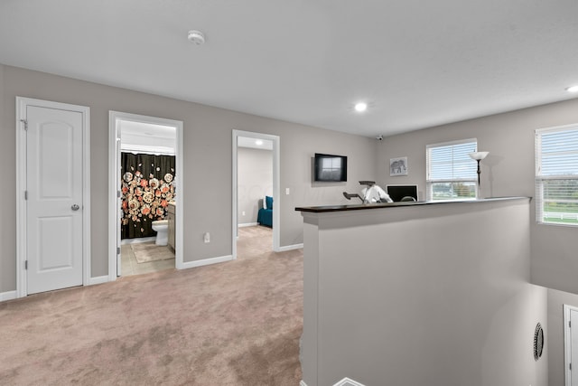 kitchen featuring kitchen peninsula and light colored carpet