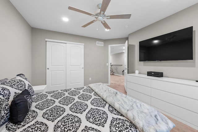 carpeted bedroom with ceiling fan and a closet