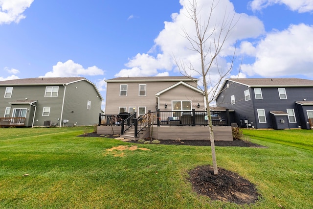 back of house featuring a lawn and a wooden deck