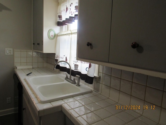 bathroom with sink and tasteful backsplash