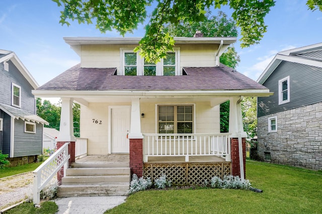 view of front facade featuring covered porch and a front yard