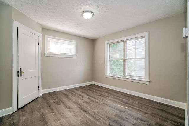 spare room with a textured ceiling and hardwood / wood-style flooring