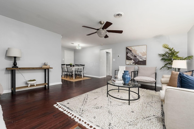 living room with ceiling fan and dark wood-type flooring