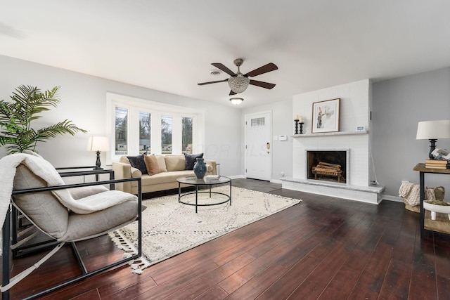 living room with a fireplace, wood-type flooring, and ceiling fan