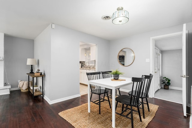 dining space featuring sink and dark hardwood / wood-style floors