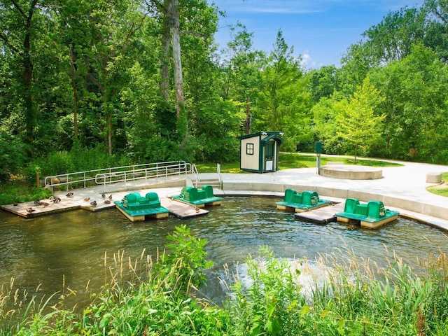 surrounding community featuring a boat dock, a water view, and an outdoor structure