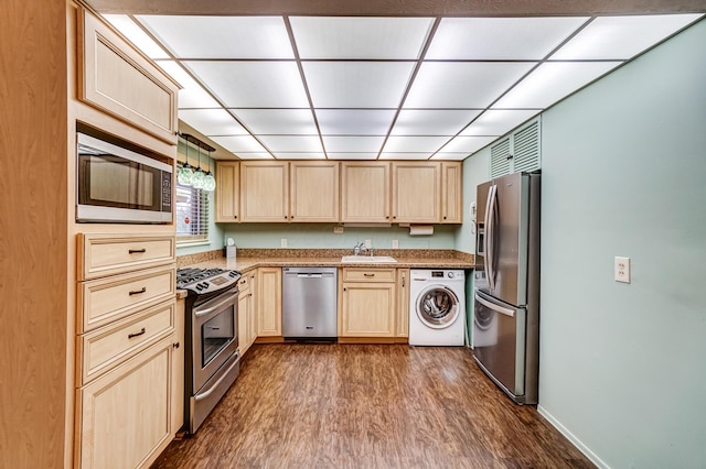 kitchen with light brown cabinets, sink, dark hardwood / wood-style floors, appliances with stainless steel finishes, and washer / clothes dryer