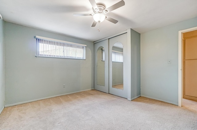 unfurnished bedroom with ceiling fan, a closet, and light carpet