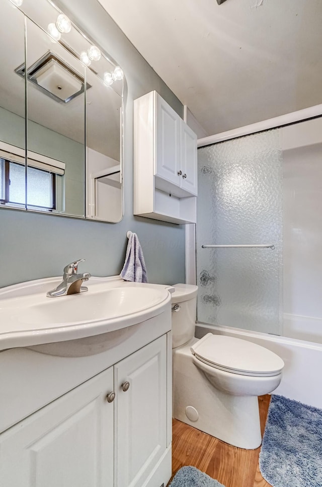 full bathroom with vanity, hardwood / wood-style flooring, toilet, and  shower combination