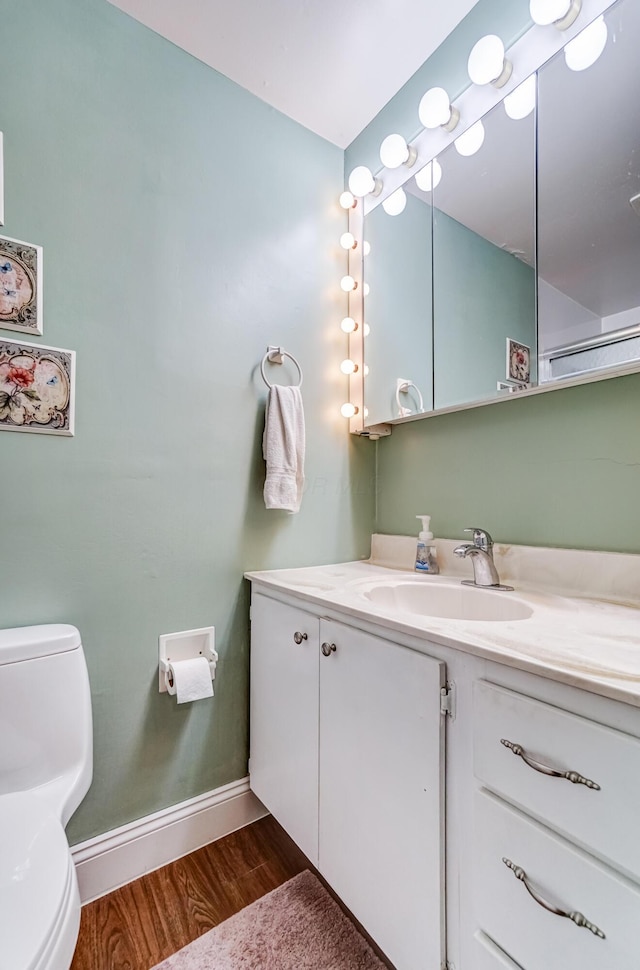 bathroom with vanity, toilet, and wood-type flooring