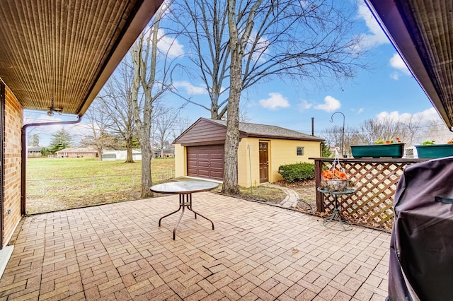 view of patio / terrace with an outbuilding, a garage, and grilling area