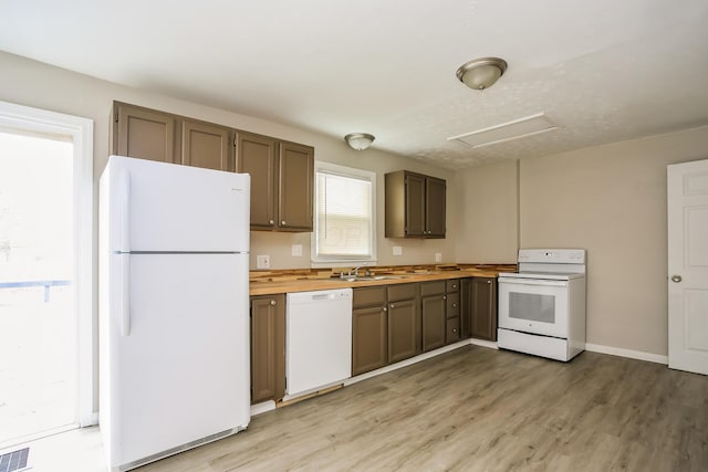 kitchen with sink, wooden counters, white appliances, and light wood-type flooring