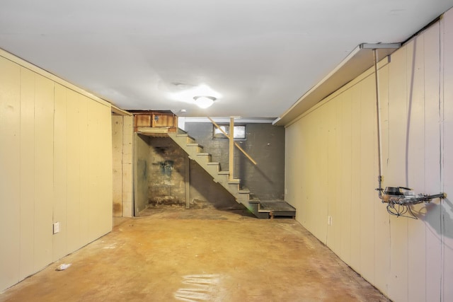 basement featuring wooden walls