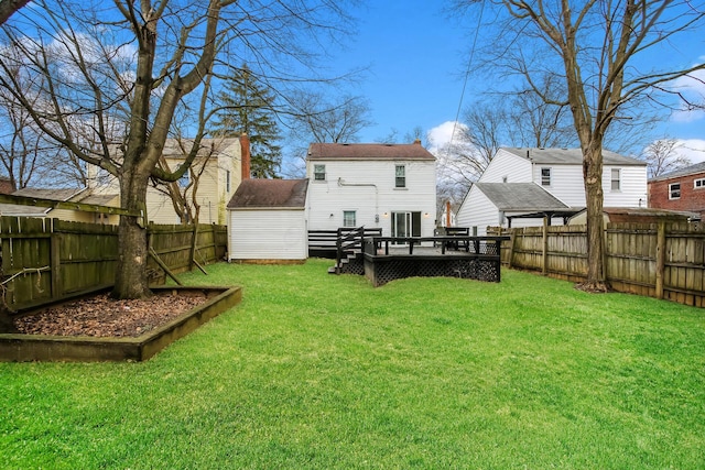 rear view of house with a lawn and a wooden deck