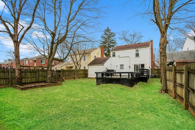 rear view of property featuring a lawn and a wooden deck