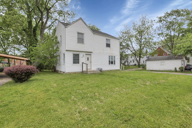 rear view of property with a lawn and an outbuilding