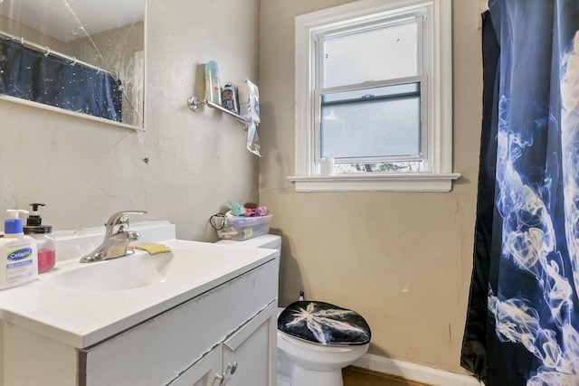 bathroom featuring walk in shower, vanity, and toilet