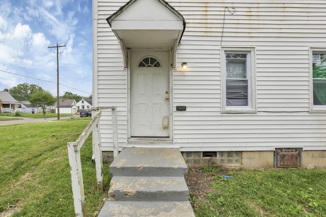 entrance to property with a lawn