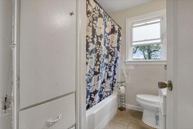 bathroom featuring tile patterned flooring, shower / bath combination with curtain, and toilet