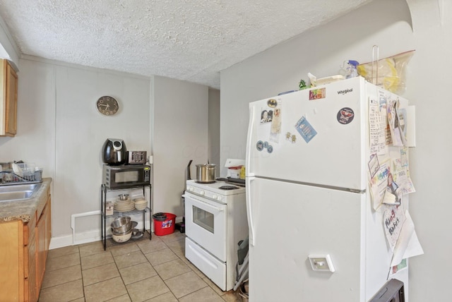 kitchen with a textured ceiling, sink, light tile patterned floors, and white appliances