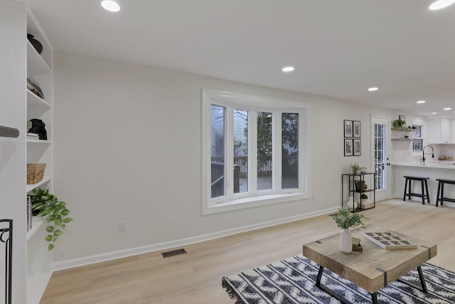 living room featuring light wood-type flooring and sink