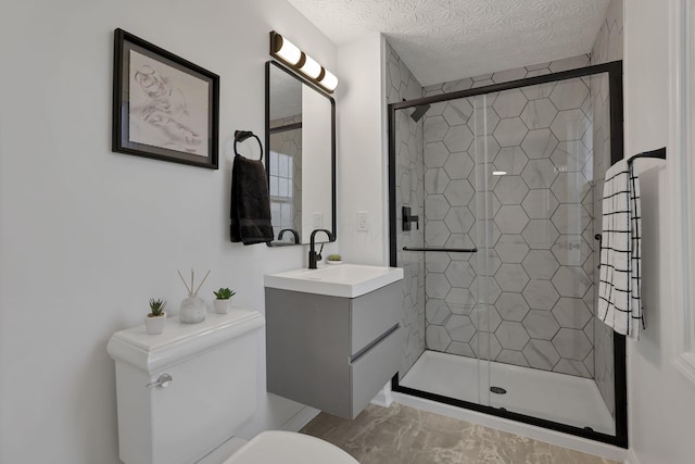 bathroom featuring vanity, a textured ceiling, toilet, and a shower with shower door