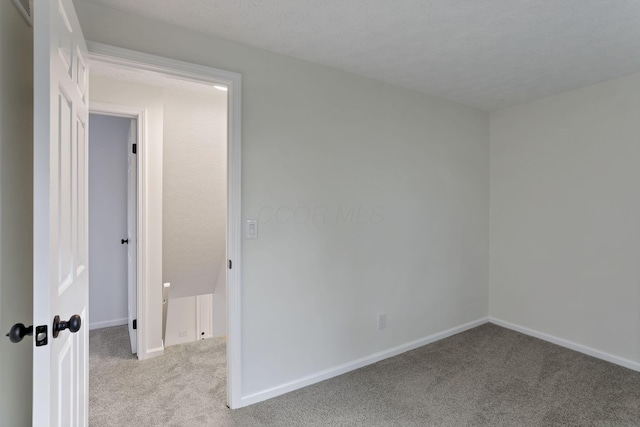 carpeted spare room featuring a textured ceiling