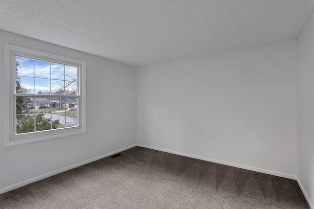 carpeted empty room featuring a textured ceiling