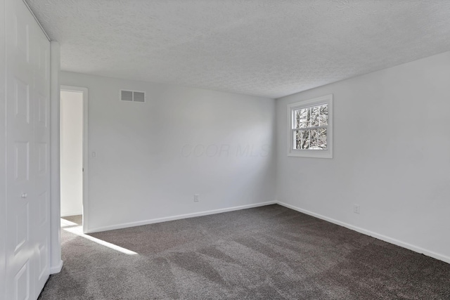 carpeted spare room featuring a textured ceiling