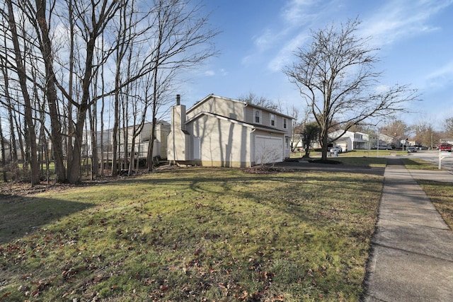 view of side of home featuring a lawn and a garage