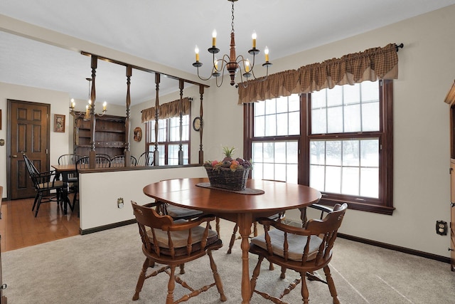 dining area with light colored carpet and a notable chandelier