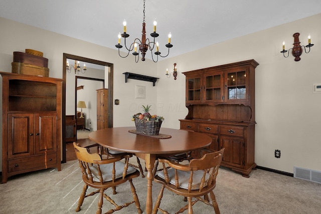 dining area featuring light colored carpet and a chandelier