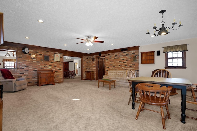 dining area featuring light colored carpet, ceiling fan with notable chandelier, and a textured ceiling